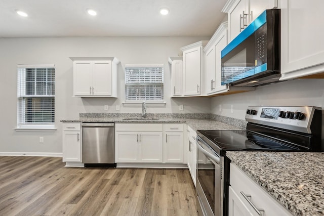 kitchen featuring white cabinets, light hardwood / wood-style floors, sink, and stainless steel appliances