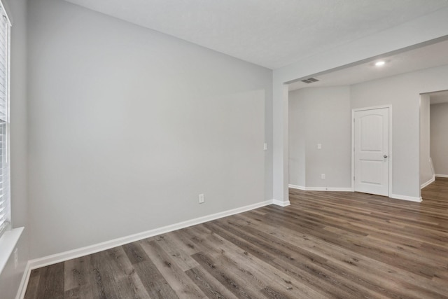 unfurnished room with dark wood-type flooring