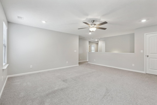 unfurnished room with ceiling fan, plenty of natural light, and light carpet