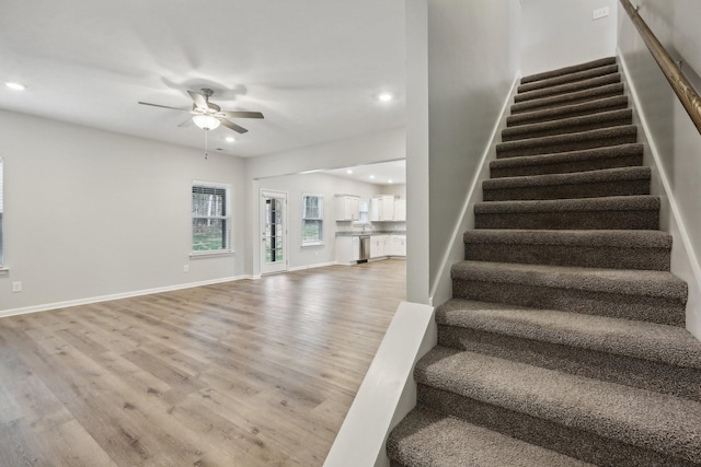 staircase featuring ceiling fan and wood-type flooring