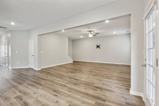 empty room with ceiling fan and light hardwood / wood-style flooring