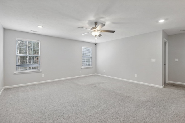 carpeted spare room featuring ceiling fan and a healthy amount of sunlight