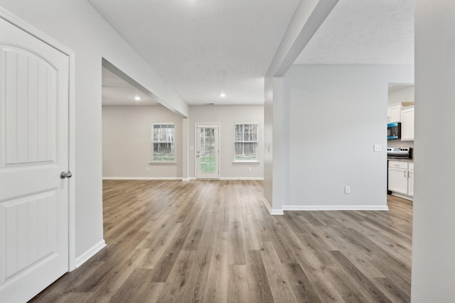 unfurnished living room featuring a textured ceiling and light wood-type flooring