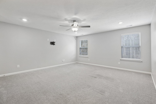 carpeted spare room with a wealth of natural light and ceiling fan