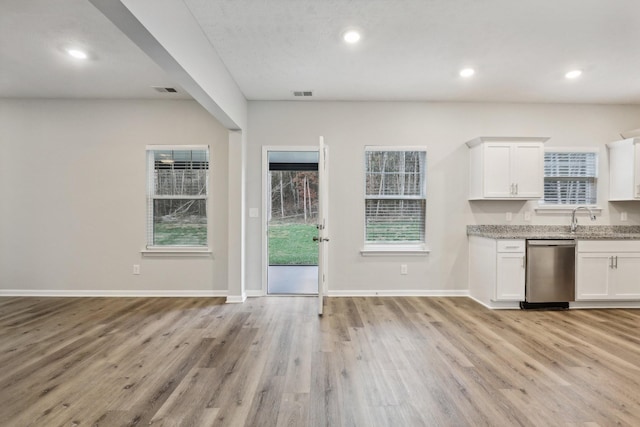 kitchen with white cabinets, stainless steel dishwasher, and light wood-type flooring