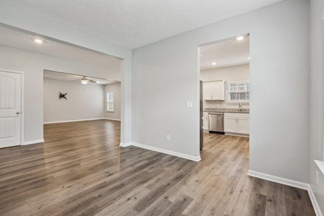 unfurnished living room featuring light wood-type flooring and ceiling fan