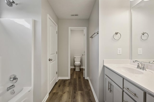 full bathroom featuring shower / bathing tub combination, hardwood / wood-style floors, vanity, and toilet