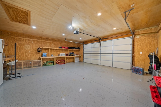 garage featuring a garage door opener and wooden walls