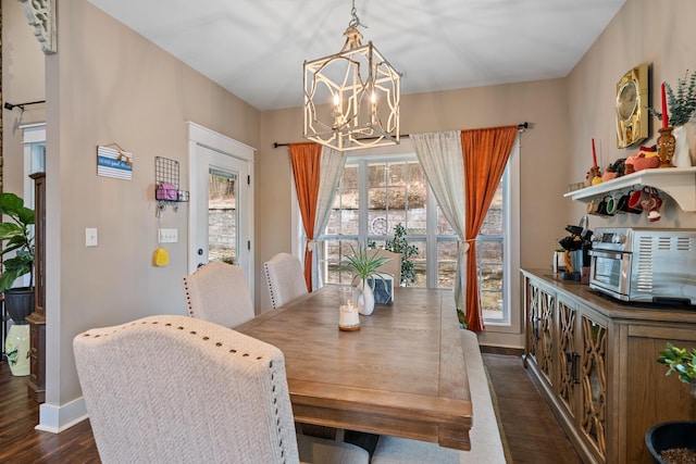 dining room with dark hardwood / wood-style floors and an inviting chandelier