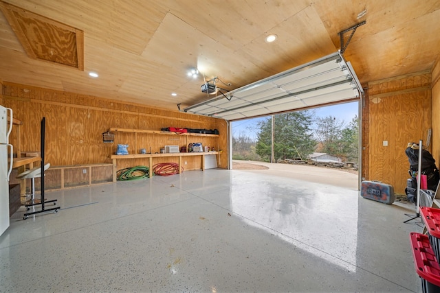 garage featuring a garage door opener and wood walls