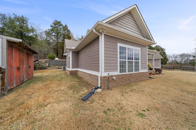 view of side of property with a lawn and cooling unit