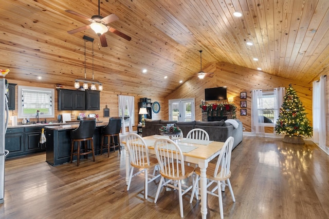 dining area with wood ceiling, wooden walls, light hardwood / wood-style flooring, and a healthy amount of sunlight