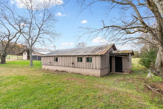 view of side of property with a lawn and an outbuilding