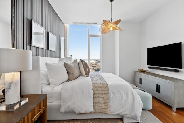 bedroom with floor to ceiling windows and hardwood / wood-style flooring