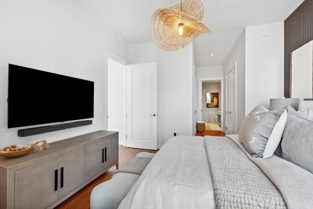 bedroom featuring ensuite bathroom and wood-type flooring