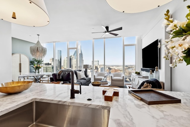 living room featuring floor to ceiling windows, ceiling fan, and a healthy amount of sunlight