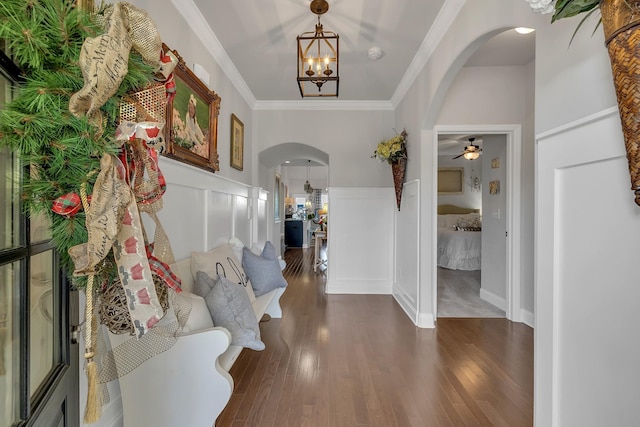 foyer with crown molding, dark hardwood / wood-style flooring, and ceiling fan with notable chandelier