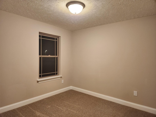 empty room featuring carpet and a textured ceiling