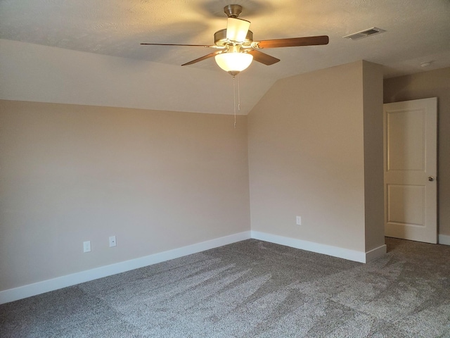 carpeted spare room featuring a textured ceiling, ceiling fan, and lofted ceiling