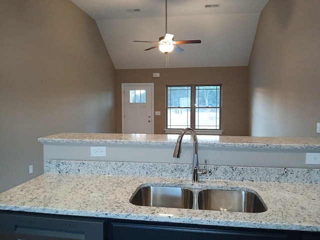 kitchen featuring light stone counters, sink, ceiling fan, and vaulted ceiling