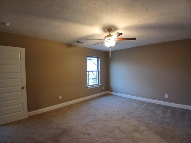 carpeted spare room with ceiling fan and a textured ceiling