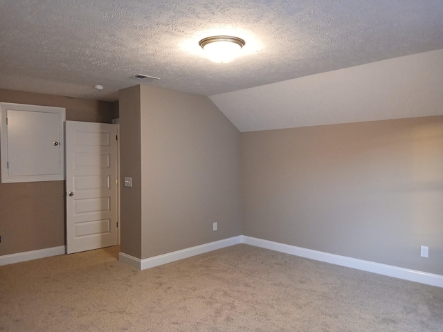 bonus room featuring lofted ceiling, light carpet, and a textured ceiling