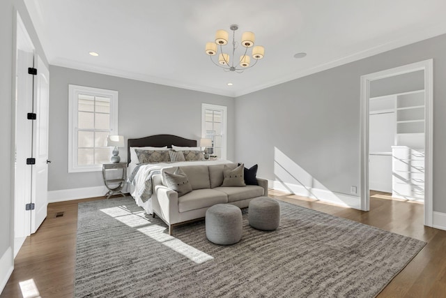 bedroom with dark wood-type flooring, a notable chandelier, and ornamental molding