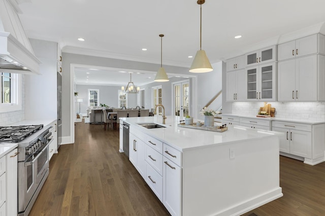 kitchen featuring white cabinetry, sink, stainless steel appliances, dark hardwood / wood-style floors, and a center island with sink