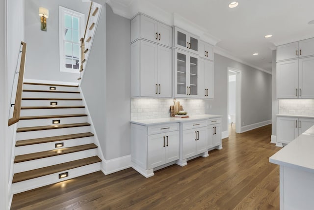 kitchen with white cabinets, dark hardwood / wood-style floors, and crown molding