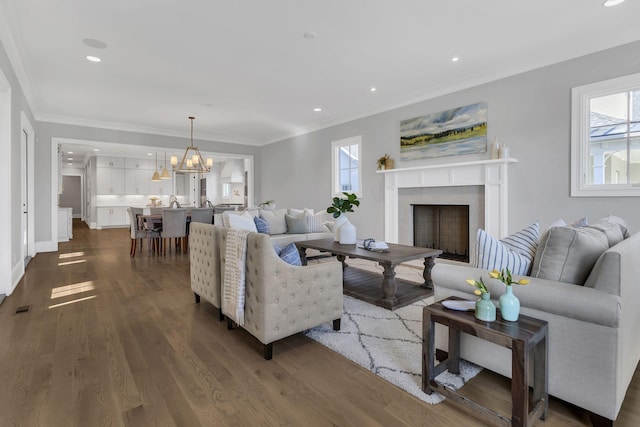 living room featuring dark hardwood / wood-style flooring, ornamental molding, and a wealth of natural light