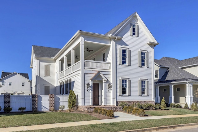 view of front of house featuring a front yard, a balcony, and ceiling fan