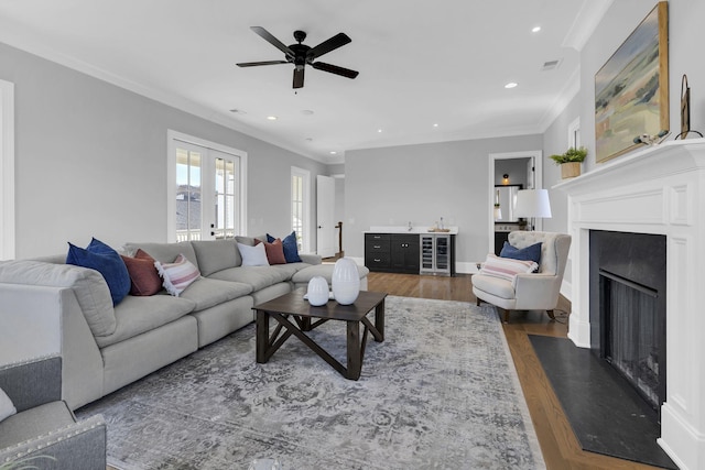 living room with dark hardwood / wood-style floors, ceiling fan, ornamental molding, and french doors