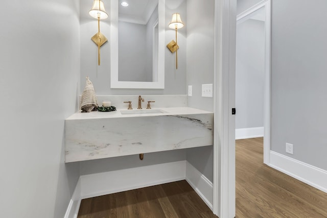 bathroom with hardwood / wood-style floors, ornamental molding, and sink