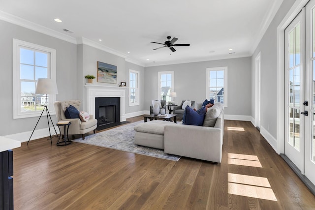 living room featuring a wealth of natural light, ceiling fan, dark wood-type flooring, and ornamental molding