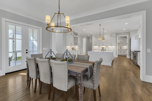 dining space with ornamental molding, french doors, dark wood-type flooring, and an inviting chandelier