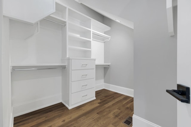 spacious closet with dark hardwood / wood-style flooring