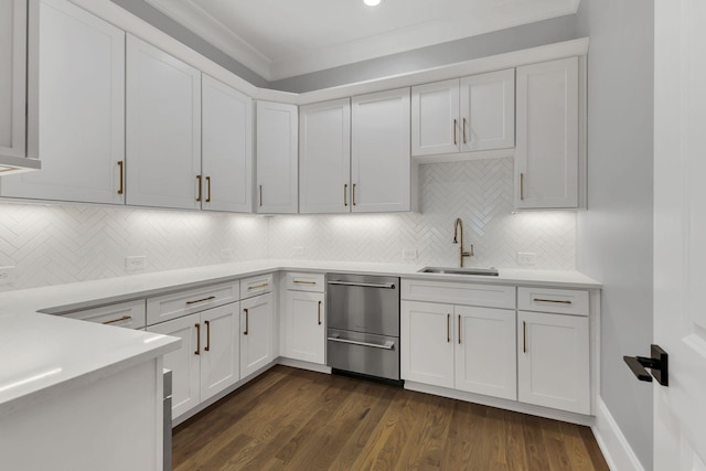 kitchen featuring sink, dark wood-type flooring, backsplash, crown molding, and white cabinets