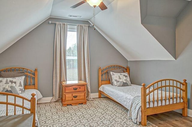 bedroom with light hardwood / wood-style flooring, vaulted ceiling, and ceiling fan