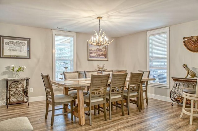 dining room featuring wood-type flooring and an inviting chandelier