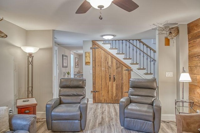 living room featuring ceiling fan and light hardwood / wood-style floors