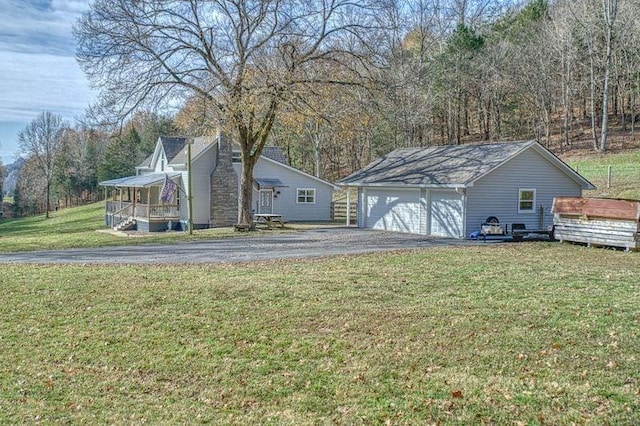 exterior space with a porch, a yard, a garage, and an outdoor structure