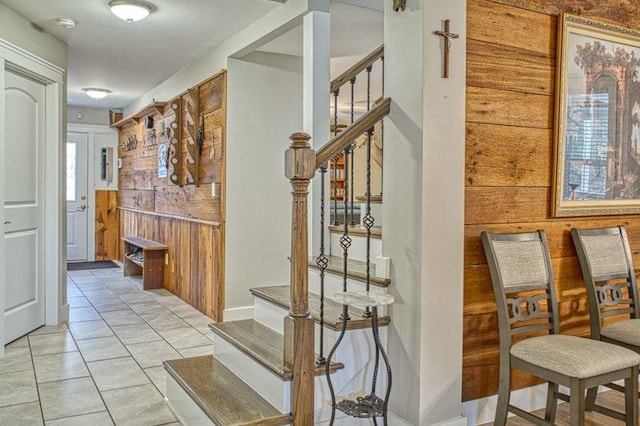 corridor with wood walls and light tile patterned floors