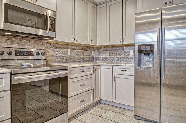 kitchen with decorative backsplash, stainless steel appliances, and light stone counters