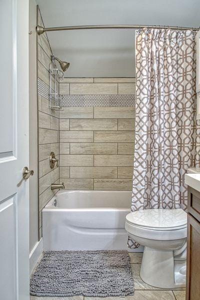 full bathroom featuring tile patterned flooring, vanity, shower / bath combo, and toilet