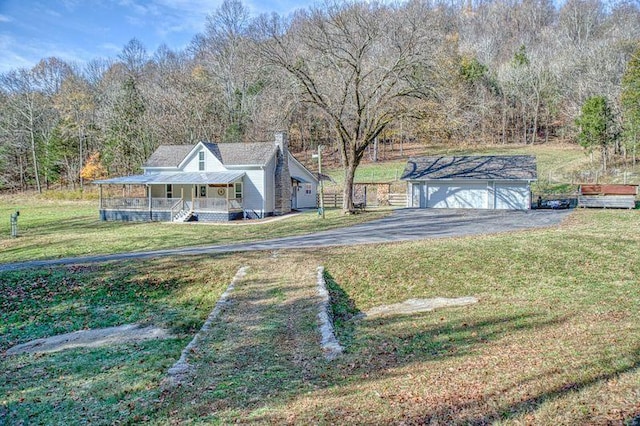 view of yard with an outbuilding, covered porch, and a garage