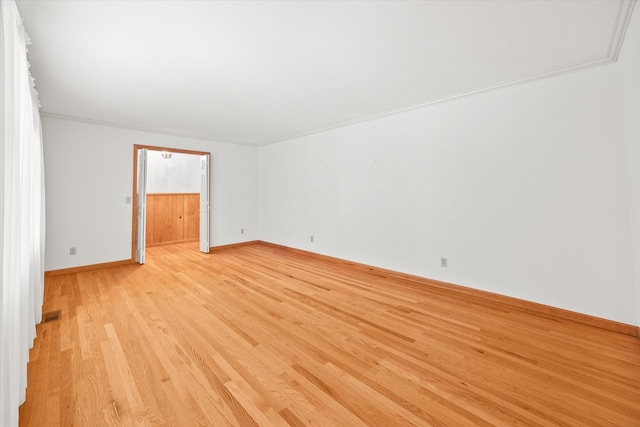 unfurnished room with light wood-type flooring and crown molding