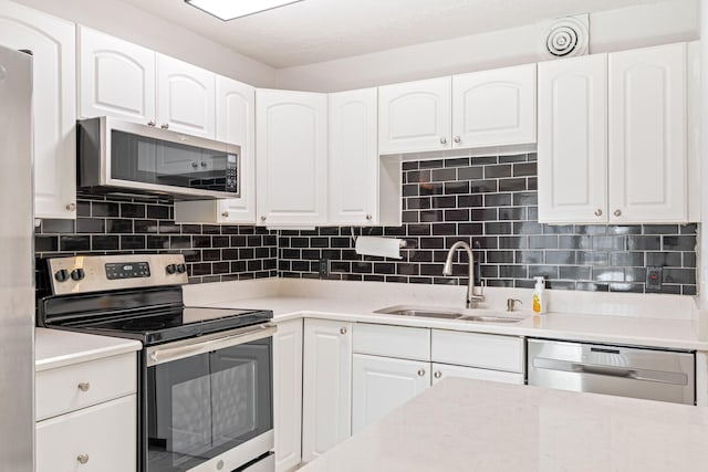 kitchen featuring stainless steel appliances, white cabinetry, and sink