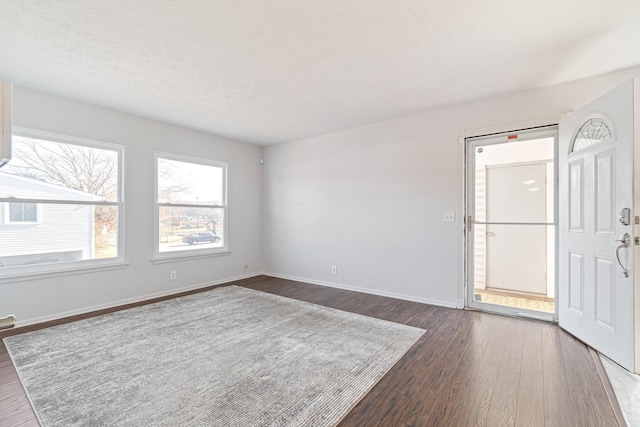 unfurnished room with dark wood-type flooring and a textured ceiling