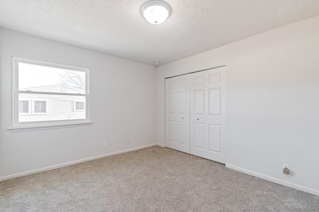 unfurnished bedroom with a closet, a textured ceiling, and carpet flooring