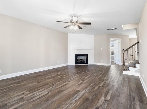 unfurnished living room with dark wood-type flooring and ceiling fan